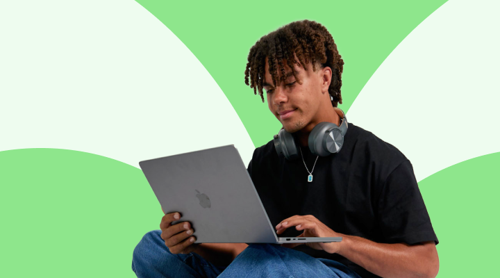 Person using a laptop with a green and white abstract background