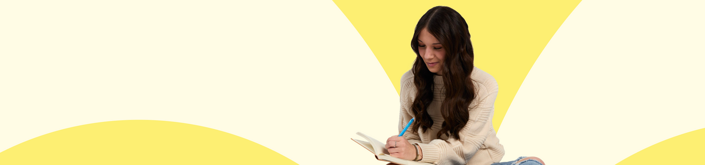 Woman sitting and writing with a yellow and beige background