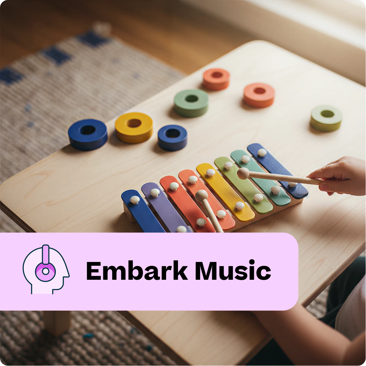 Child playing with a colorful wooden xylophone on a table, with 'Embark Music' branding.