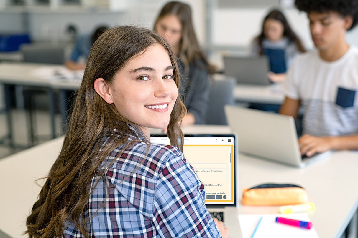 Young woman smiling in a classroom with classmates using laptops