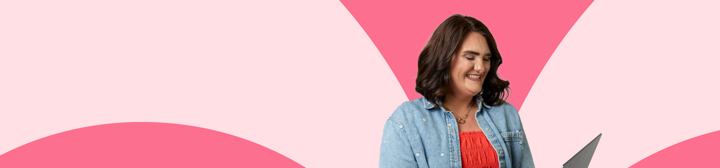 Woman standing against a pink geometric background
