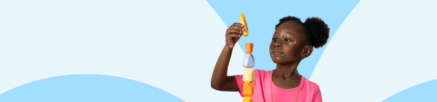 Young girl holding a colorful toy against a blue background