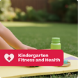 Child sitting on a mat outdoors with a green bottle, text 'Kindergarten Fitness and Health' overlay.