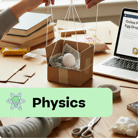 Cardboard box with an egg held aloft by string on a desk with a laptop displaying 'Online Physics Egg Drop' project.