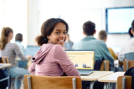 Student using a laptop in a classroom setting