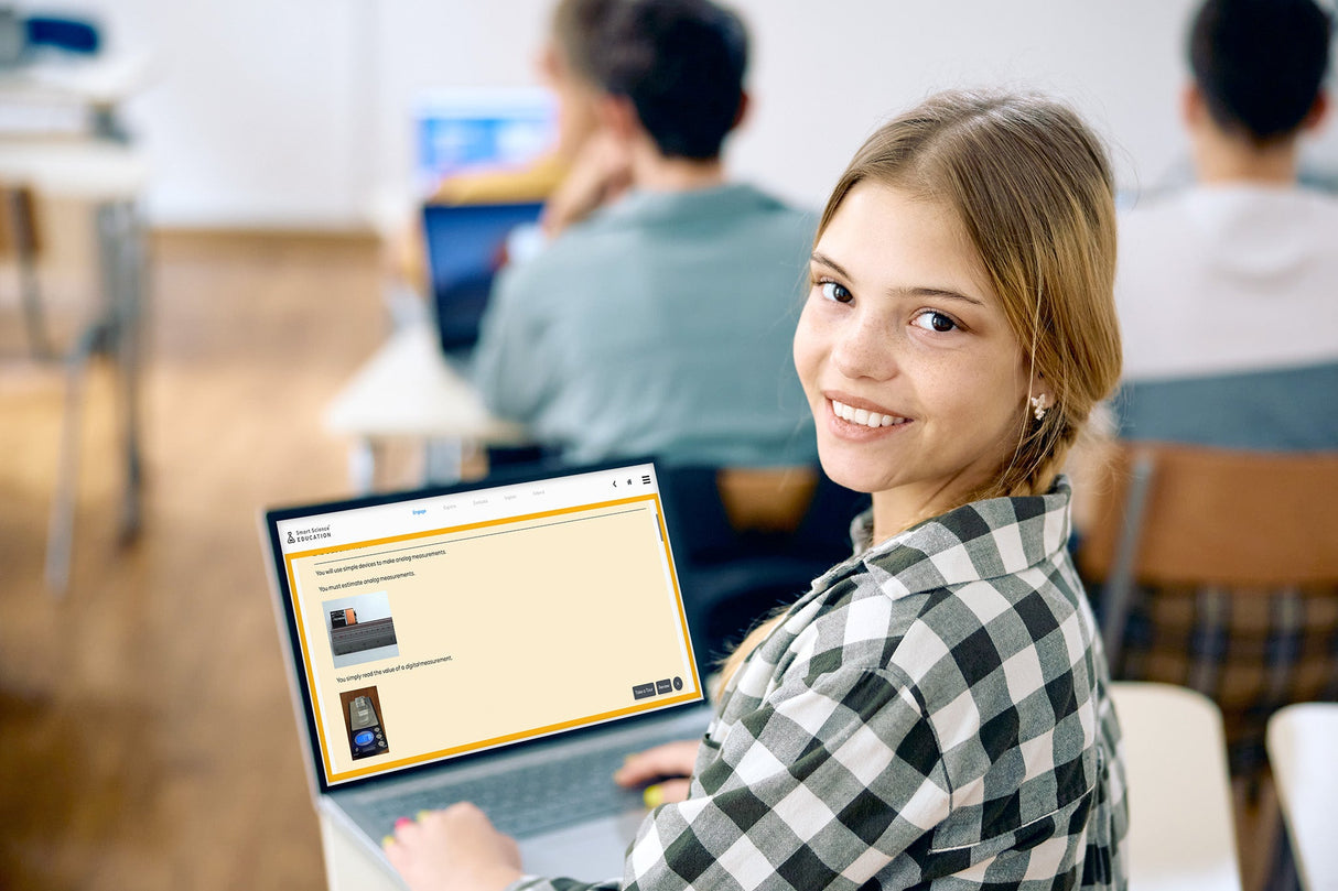 Woman using a laptop in a classroom setting with blurred background
