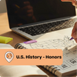 Person studying U.S. History with a map and notebook on a desk, text overlay 'U.S. History - Honors'.